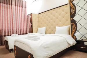 a bedroom with a large bed with a padded headboard at Khujand Star in Khujand