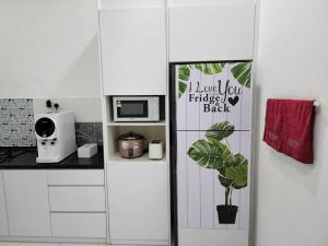 a kitchen with a refrigerator with a plant in it at Hud D'Lipis Homestay in Kuala Lipis