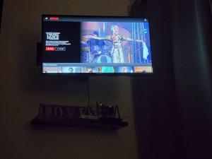 TV de pantalla plana colgada en la pared en Hud D'Lipis Homestay, en Kuala Lipis