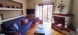 a living room with a blue couch and a fireplace at ZeusPlace Litochoro Central Traditional House in Litochoro