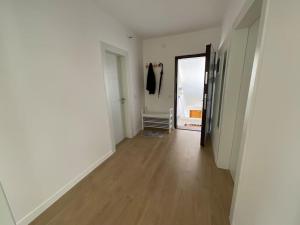 an empty room with a hallway with a wooden floor at Spring apartment in Permet in Përmet