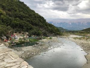 a river with a group of people standing in the water at Spring apartment in Permet in Përmet