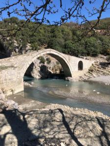 a stone bridge over a river in a canyon at Spring apartment in Permet in Përmet