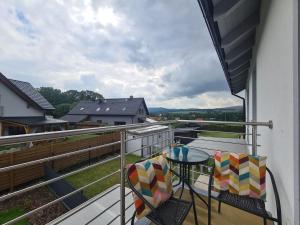 a balcony with a table and chairs and a view at APARTAMENTY "LA VILLA SUPERIOR II" z dwoma sypialniami, balkonem i parkingiem in Kudowa-Zdrój