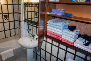 un bagno con lavandino e un mucchio di asciugamani di ZeusPlace Litochoro Central Traditional House a Litóchoron