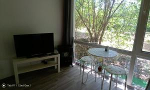 een woonkamer met een tafel en stoelen en een raam bij Граничар 3 СЪРФА in Granichar