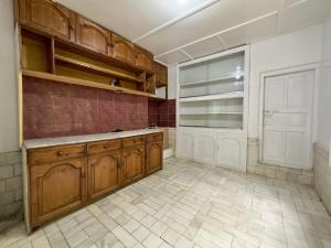 una cocina con armarios de madera y una puerta blanca en Sultan's Guest House, en Skardu