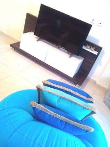 una almohada azul sentada en el suelo junto a una TV en Villa Fokea en Nea Fokea