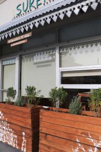 a store front with potted plants in front of it at Sureño in Puerto Pirámides