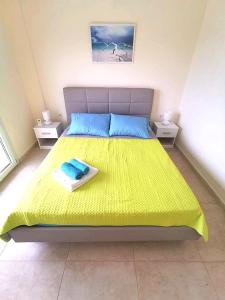 1 dormitorio con 1 cama amarilla grande y 2 mesas en Villa Fokea en Nea Fokea