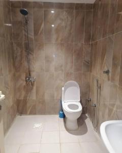 a bathroom with a toilet and a shower and a sink at ديار الفارس in Yanbu