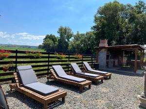 a row of lounge chairs sitting next to a fence at Casa cu Flori Maramures 