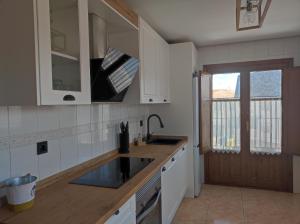a kitchen with white cabinets and a sink and a window at La Casa del Valle 2 in Soncillo +5 photos
