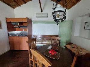 a kitchen with a table with a bowl of fruit on it at Elma's Houses - Green House Yanna in Alonnisos Old Town +17 photos