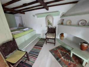 a room with a bed and a desk and chairs at Elma's Houses - Green House Yanna in Alonnisos