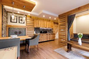 a kitchen with wooden cabinets and a wooden table at Willa Tatiana Boutique in Zakopane