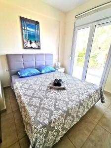 1 dormitorio con 1 cama grande con colcha azul y blanca en Villa Fokea en Nea Fokea