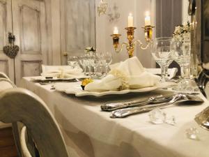 einen weißen Tisch mit Gläsern und Besteck auf dem Tisch in der Unterkunft L’île aux fleurs in Ventabren