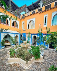 un gran edificio naranja con un patio con plantas en Riad Hicham, en Chefchaouen