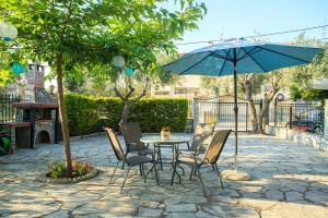 a patio with a table and chairs and an umbrella at Villa Irene in Pefkohori