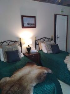 a bedroom with two beds with green comforters and a fur at La Chevallerie - Tranquil oasis in Isigny-le-Buat