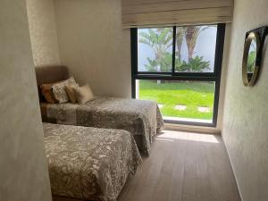 a room with two beds and a window at Appartement de luxe, front de mer Plage des nations in Salé