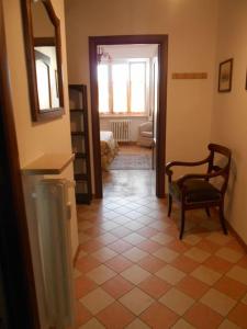 ein Wohnzimmer mit einem Stuhl und einem Spiegel in der Unterkunft allo Sferisterio, Cuneo in Cuneo