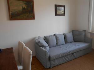 ein Wohnzimmer mit einem blauen Sofa und einem Gemälde in der Unterkunft allo Sferisterio, Cuneo in Cuneo