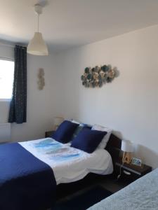 sypialnia z dużym łóżkiem z niebieskimi poduszkami w obiekcie la java w mieście Saint-Cyran-du-Jambot