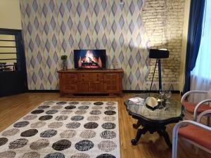 a living room with a tv and a table at Riverside Old Town Spacious Apartment few steps from Dome square and Cathedral in Riga +42 photos