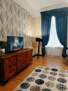 Riverside Old Town Spacious One Bedroom Apartment في ريغا: غرفة معيشة مع تلفزيون بشاشة مسطحة على خزانة