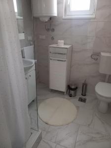 Un baño blanco con inodoro y lavabo. en Apartman Flora Vrdnik, en Vrdnik 18 fotos más