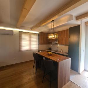 a kitchen with a wooden island in a room at Orahovo stone vilas in Virpazar