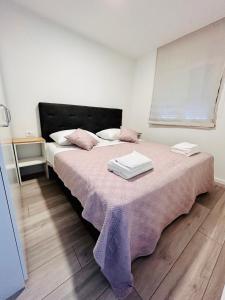 1 dormitorio con 1 cama con sábanas y almohadas rosas en Apartment Rovci 2 en Slatine