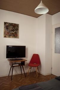 a room with a television and a red chair at Endretro Apartments in Siófok