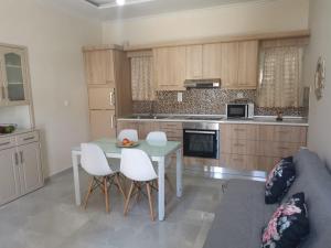 ディアファニにあるCaptain John's Apartmentのキッチン(テーブル、白い椅子付)