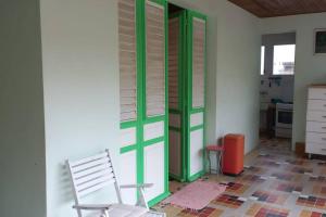 a room with two chairs and a green door at Maison spacieuse agréable in Le Morne-Vert