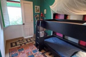 a bedroom with a bed and a window and a door at Maison spacieuse agréable in Le Morne-Vert