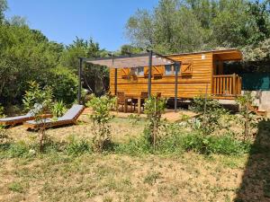 eine Blockhütte mit einer Veranda und einer Terrasse in der Unterkunft Tiny House Roulotte in Cuges-les-Pins