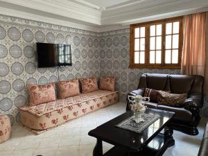 - un salon avec un canapé et une table dans l'établissement Rez-de-jardin à Mohammedia, à Mohammedia