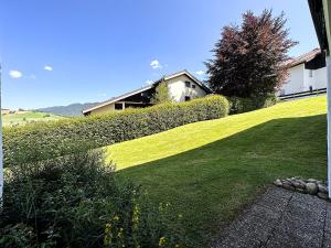 ein Haus auf einem Hügel mit grünem Rasen in der Unterkunft Cosey Corner in Oberstaufen