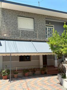 a building with awning and a balcony with plants at Vila Adriatik 1 in Vlorë