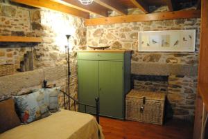 a bedroom with a green cabinet in a stone wall at Renovated old traditional House in Kos