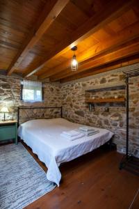a bedroom with a bed and a stone wall at Renovated old traditional House in Kos Town