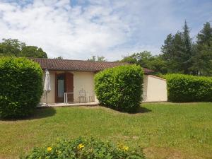 una casa con dos setos delante de un patio en The Gare Gondrin, en Gondrin