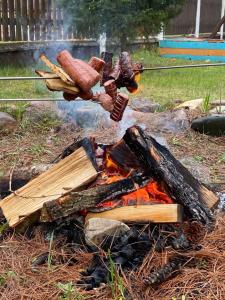 una pila de troncos y salchichas en un fuego en Agroturystyka Barycz Całoroczny Domek Marcel, en Końskie