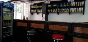 um bar com dois bancos e garrafas de cerveja em Khujand Star em Khujand