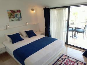 um quarto com uma cama com almofadas azuis e uma varanda em Stonehouse Aparts Dublex 3+1 mit Meerblick und Jakuzzi Kalkan No:5 em Kalkan
