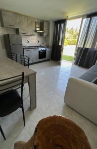 eine Küche und ein Wohnzimmer mit einem Tisch und einem Sofa in der Unterkunft Casa Vacanze Il Sole in Casamassella