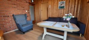 a living room with a table and a blue chair at Verkių Namelis in Vilnius +9 photos